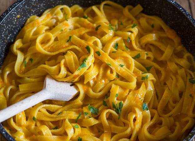 long pasta and pepper cream sauce in a black pan