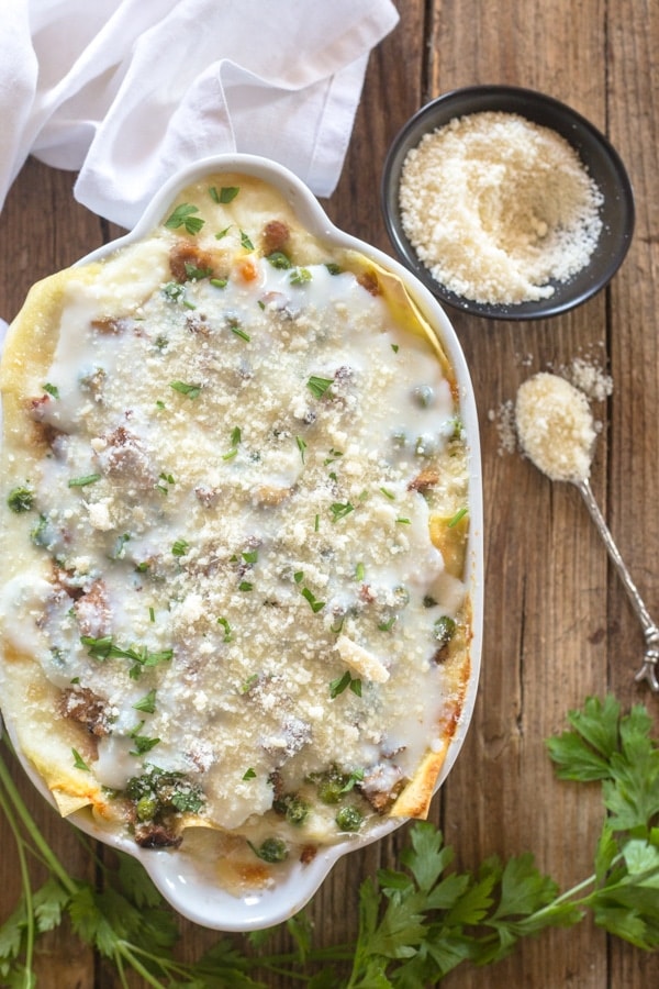 white lasagna in a white baking dish.