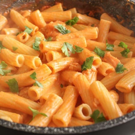 cream sauce with rigatoni pasta in a black pan