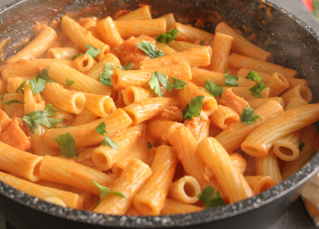 cream sauce with rigatoni pasta in a black pan