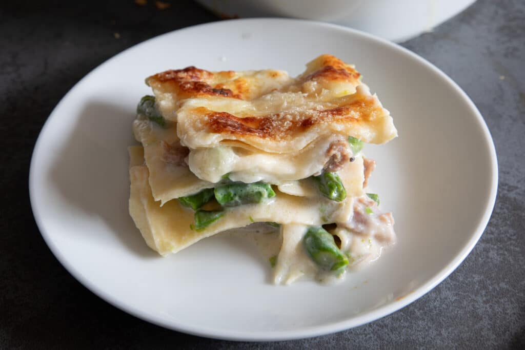 A slice of asparagus lasagna on a white plate.