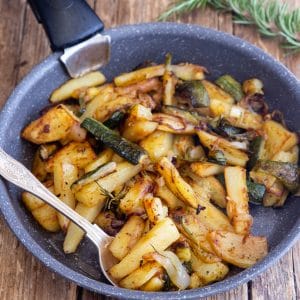 Zucchini and potatoes in a black pan.