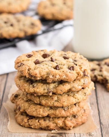 oatmeal chocolate chip cookies stacked on a wooden with a bottle of milk
