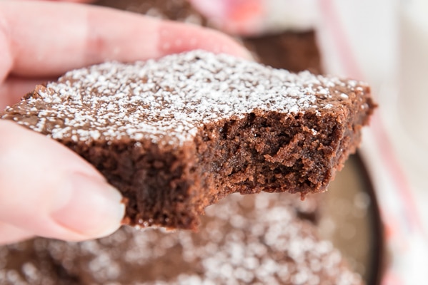 a brownie being held with a bite taken