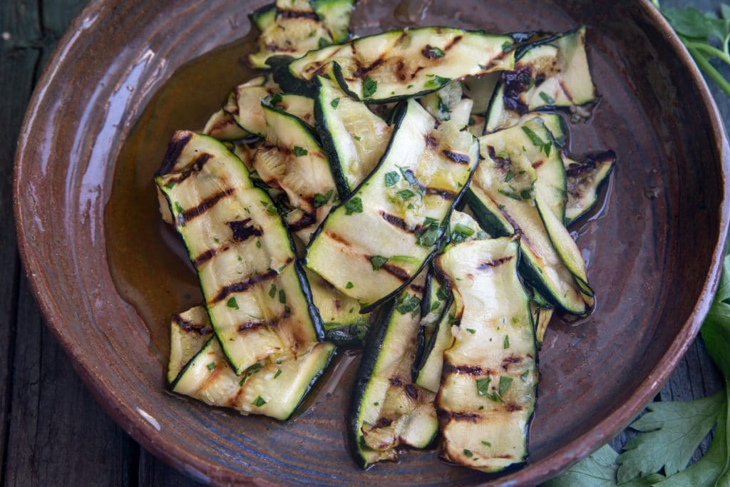 Grilled zucchini on a brown plate.
