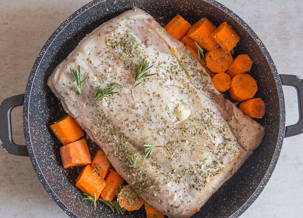 roast pork loin and carrots in a pot to be cooked