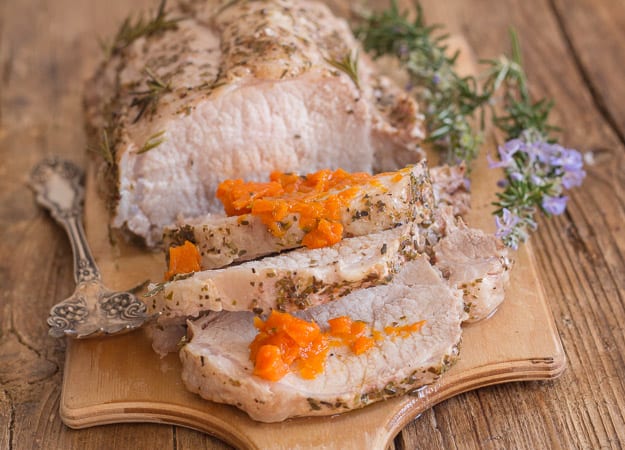 3 slices of roast pork loin on a wooden board