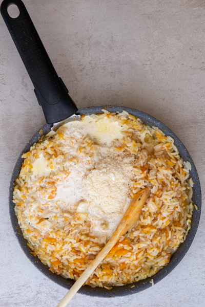 Adding the parmesan cheese and butter to the rice.