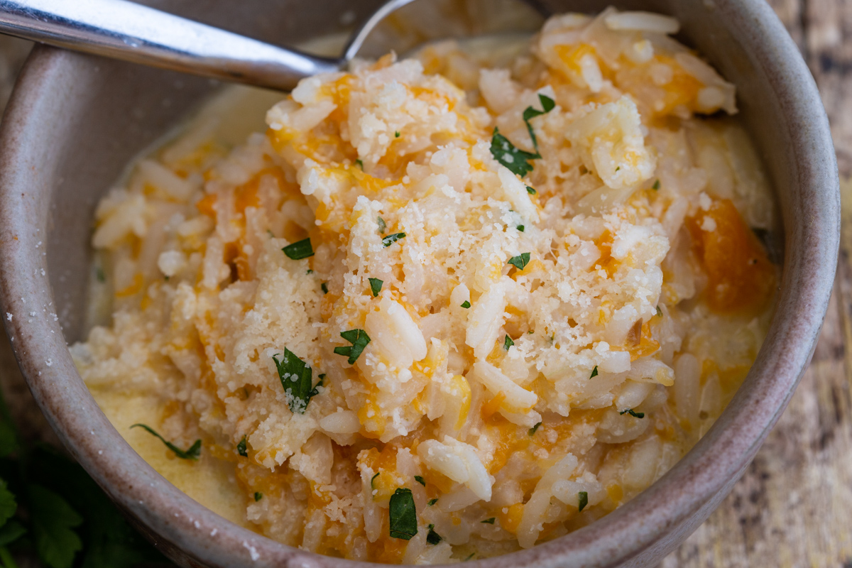 Risotto in a grey bowl with parmesan cheese.