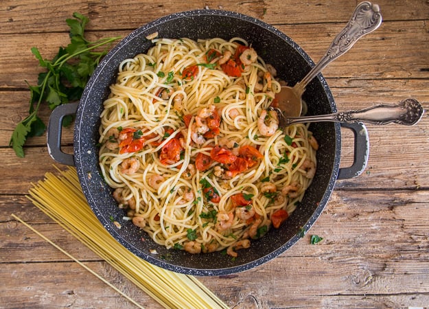 shrimp and tomato pasta cooked in a black pan