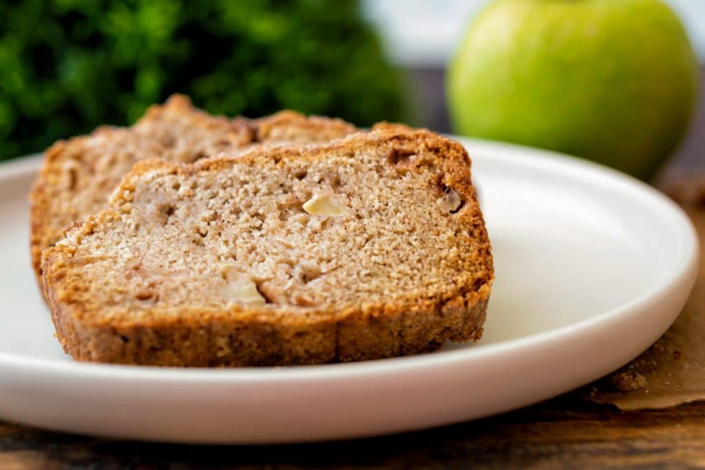 A slice of dutch apple loaf on a white plate.