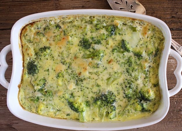 Broccoli cheese casserole in a white baking dish