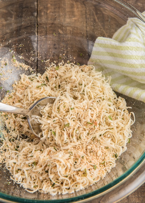 Mixing the parmesan mixture in a silver bowl.