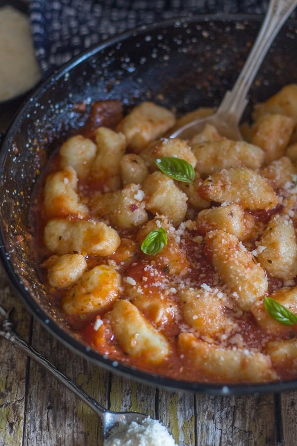 gnocchi sprinkled with parmesan in a black pan