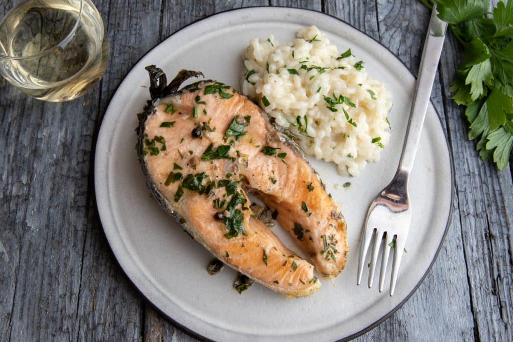 Salmon on a white plate with rice.