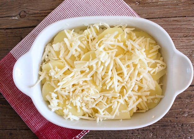 shredded cheese on the sliced potatoes for cheesy scalloped potatoes