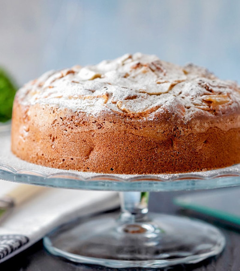 Pear cake on a glass cake stand.