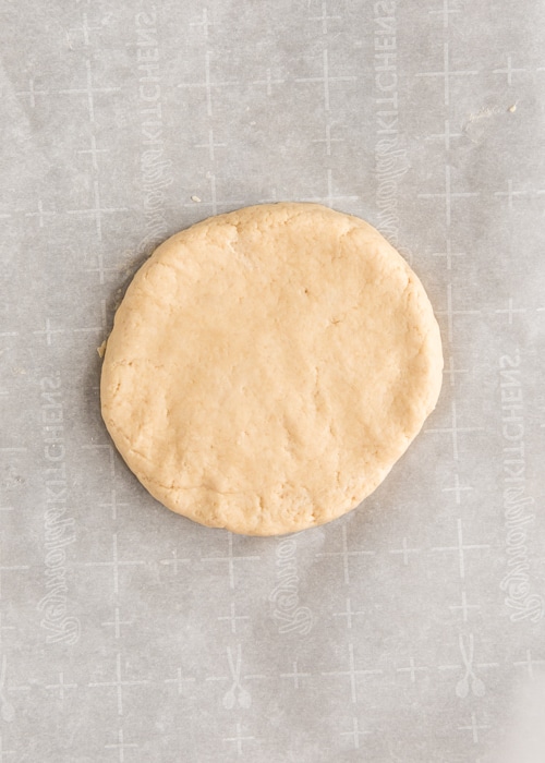 The dough flattened on parchment paper.