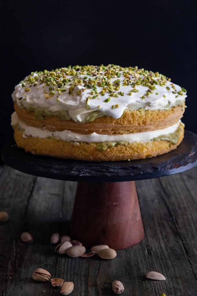 Pistachio tiramisu on a black cake dish.