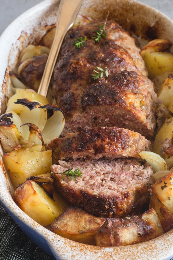 polpettone sliced with potatoes in white dish