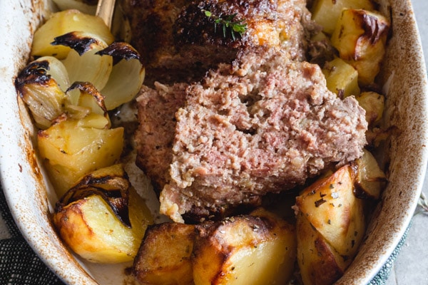 italian meatloaf with potatoes sliced in a pan