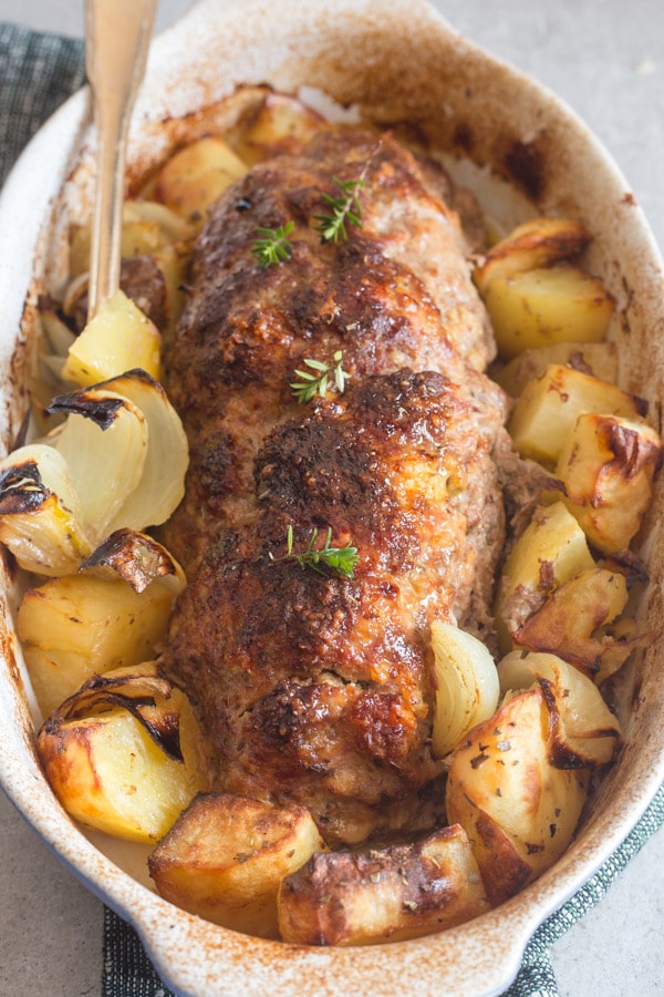 meatloaf - polpettone in a white pan with roasted potatoes
