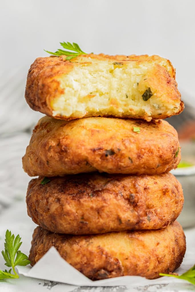 4 croquettes stacked with one with a bite out.