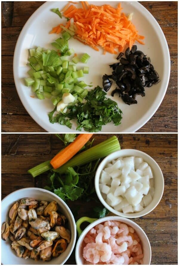 Vegetables cut up and seafood in small bowls.