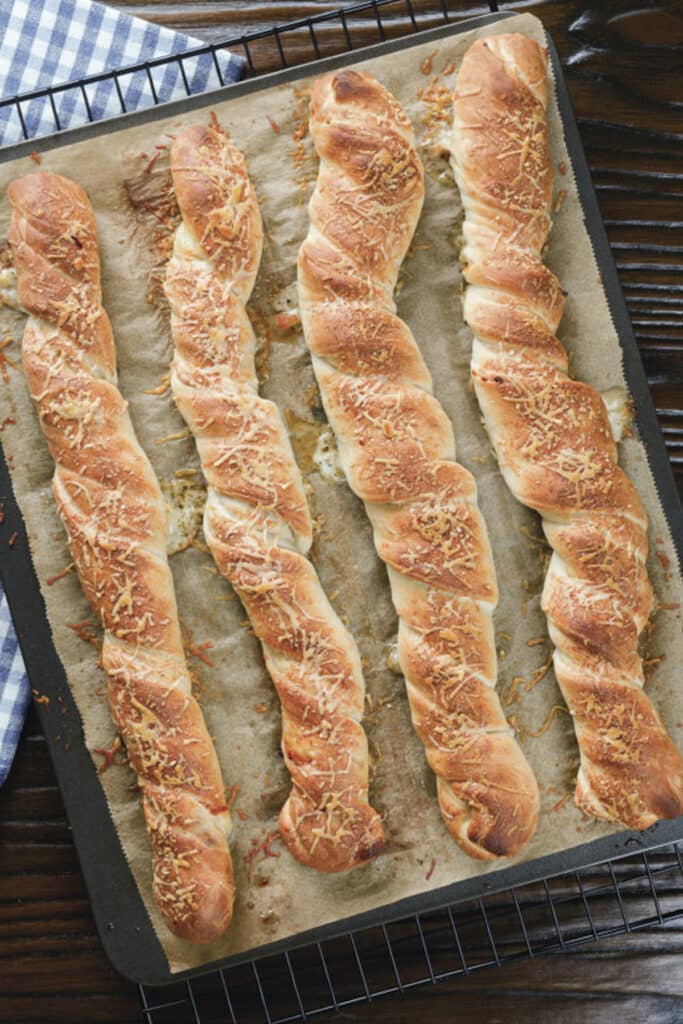 Four pizza twists on a baking sheet.