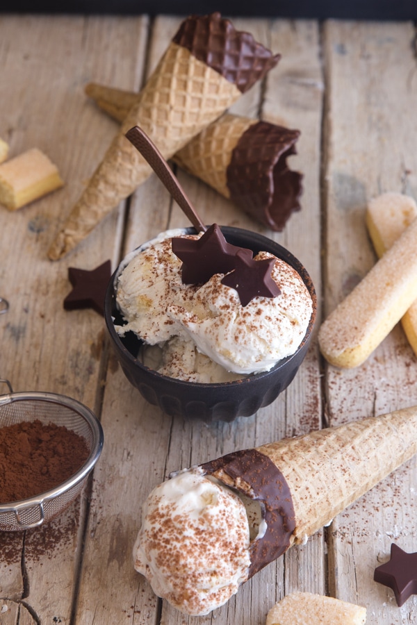 tiramisu gelato on a wooden board, in a black bowl and in a cone