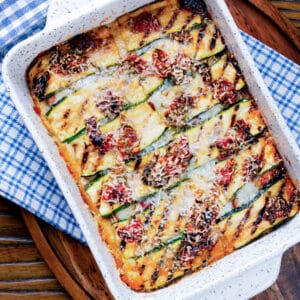 Baked zucchini in a white baking dish.