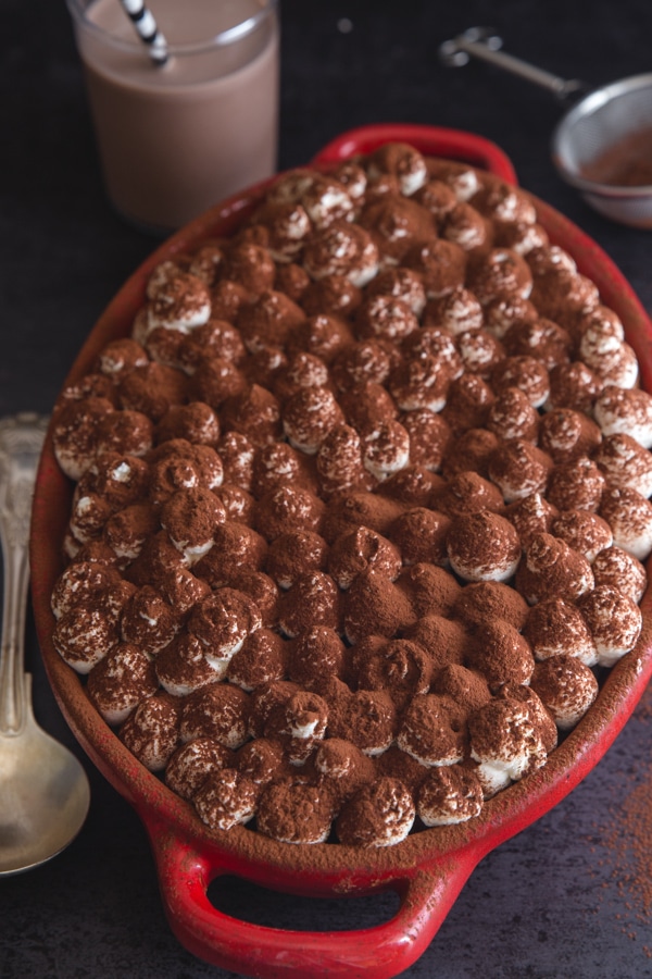 tiramisu finished in a red pan with a glass of chocolate milk