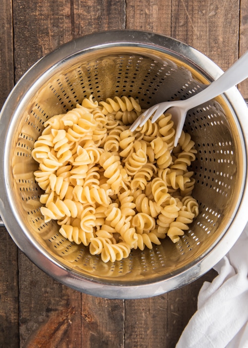The cooked pasta in a silver colander.