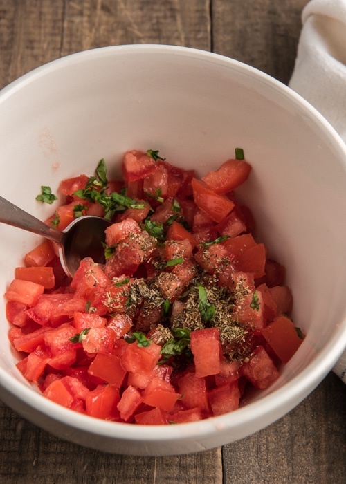 The tomato topping in a white bowl.
