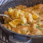 baked macaroni double cheese in a skillet with a spoonful