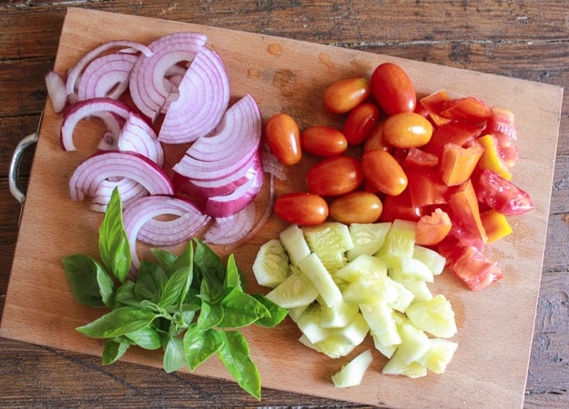 ingredients for panzanella sliced onion, tomatoes cucumber