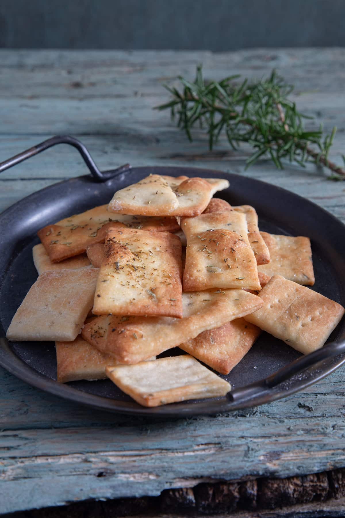 Rosemary crackers on a black plate.