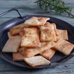 Rosemary crackers on a black plate.