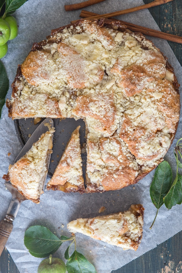 apple streusel cake with three pieces cut on white paper