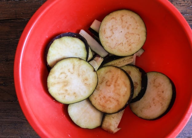 slices of eggplant in a red bowl