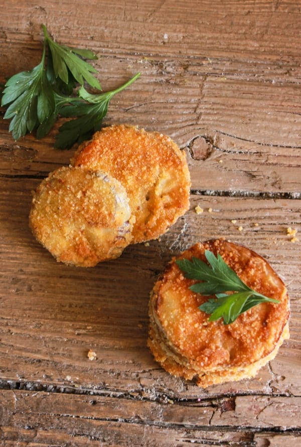 slices of breaded eggplant with parsley leaves
