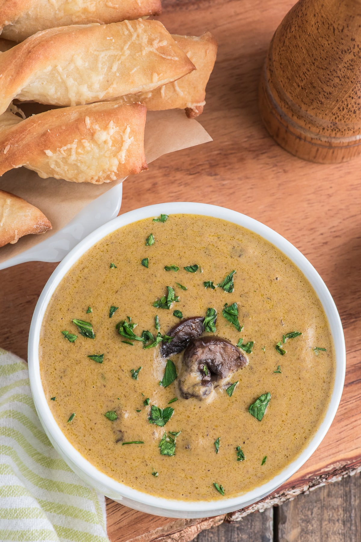 Mushroom soup in a white bowl with parmesan twists.