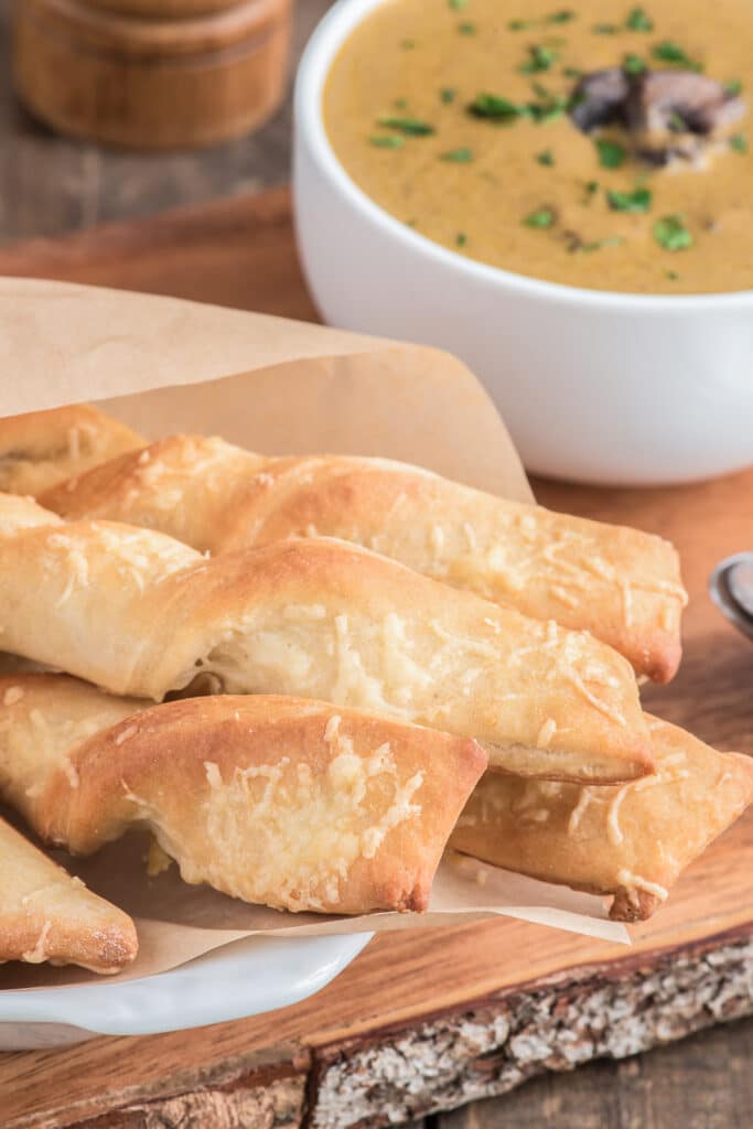 Parmesan twists and soup in a white bowl.