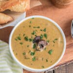 Mushroom soup in a white bowl with parmesan twists.