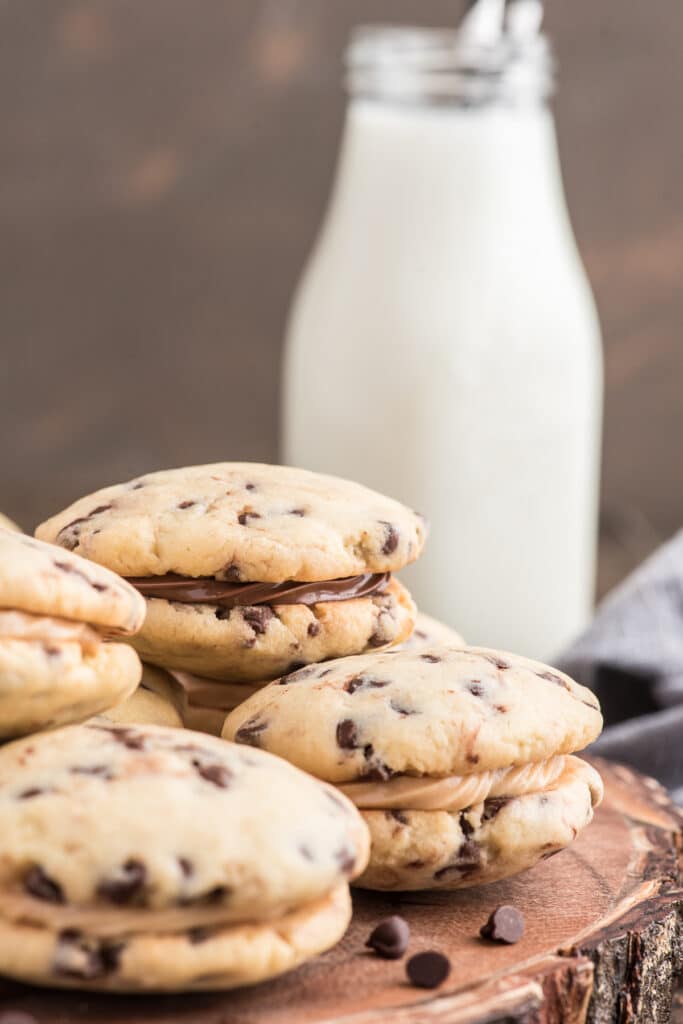 Cookies on a wooden board with a bottle of milk.