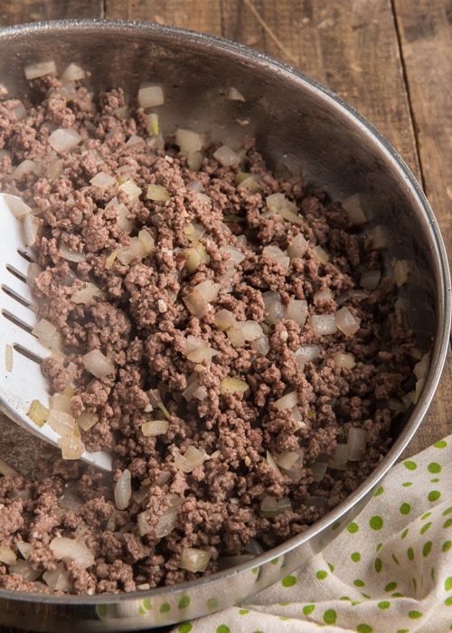 Cooking the ground beef & onions in a pan.