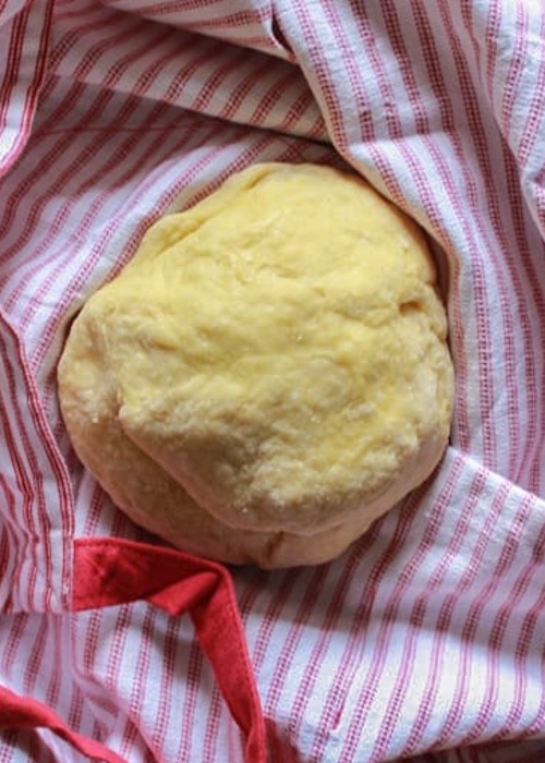 The pasta dough on a red striped napkin.