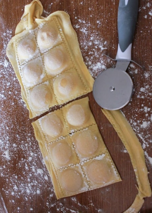 The ravioli flipped over and cutting with a pizza cutter.