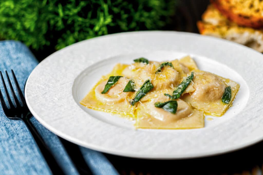 Squash ravioli on a white plate.