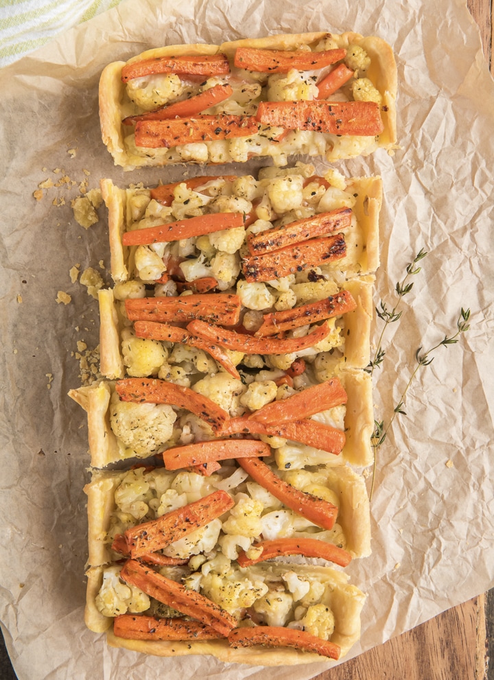 Vegetarian pie sliced on parchment paper.